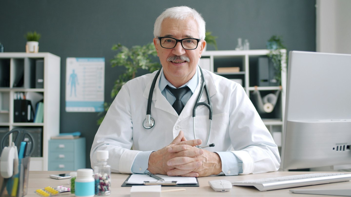 Doctor sitting at his desk in a clinic office.